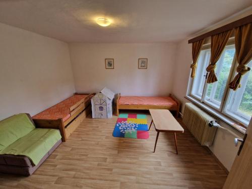ein Zimmer mit zwei Betten und einem Tisch darin in der Unterkunft Family house with garden in Karlovice