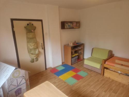 Ein Spielzimmer mit einem Stuhl und einem bunten Teppich. in der Unterkunft Family house with garden in Karlovice