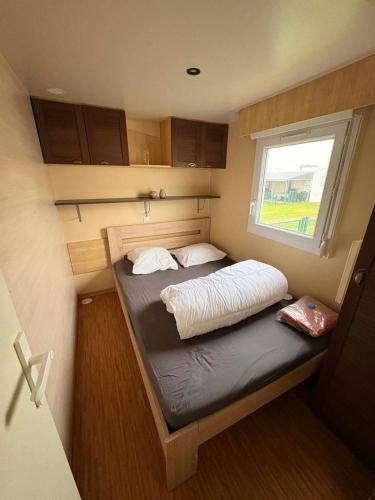 Un pequeño dormitorio con una cama en una casa diminuta. en La Lessinoise - Park Costa Bredene, en Bredene