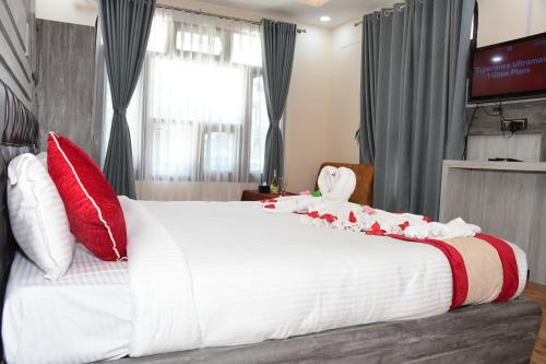 Hotel Opera في Bahāsi: غرفة نوم بسرير أبيض كبير مع وسائد حمراء