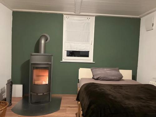 ein Schlafzimmer mit einem Bett und einem Holzofen in der Unterkunft Ferienwohnung Donauherz in Stetten