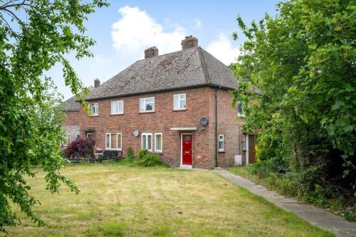 een oud bakstenen huis met een rode deur bij Keralia in Wivenhoe