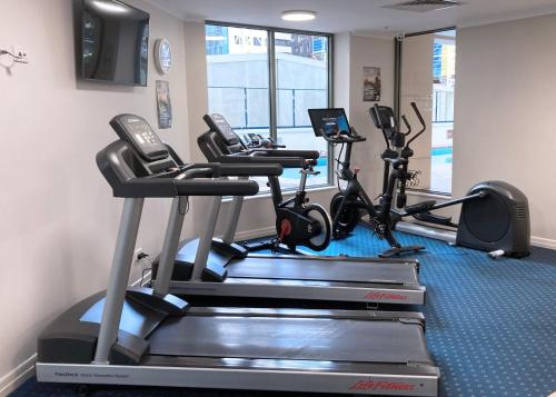 a gym with three treadmills and cardio machines at City Centre Comfort, Style and Convenience in Brisbane
