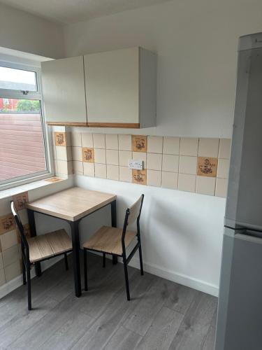 a small kitchen with a table and two chairs at Clayburn Spacious Twin Bed Large Room in Basildon