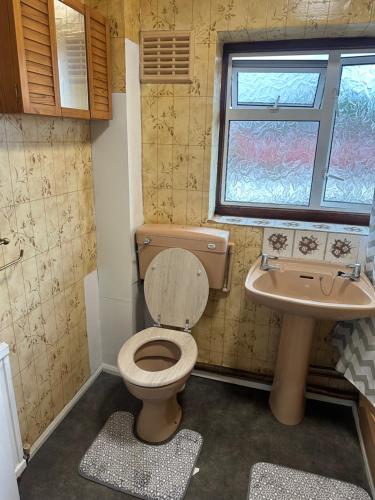 a small bathroom with a toilet and a sink at Clayburn Spacious Twin Bed Large Room in Basildon