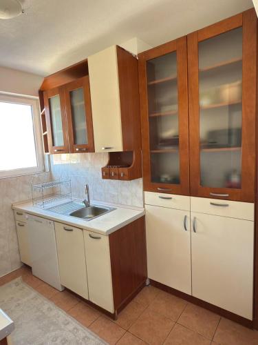 une cuisine avec des armoires en bois et un évier dans l'établissement Bar Central Stay Apartment, à Bar