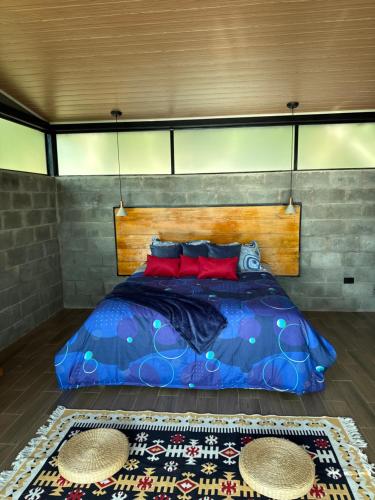 une chambre avec un lit avec des oreillers rouges dessus dans l'établissement Cabañas Ecoturísticas Villa Beatrice, à Estación El Salto