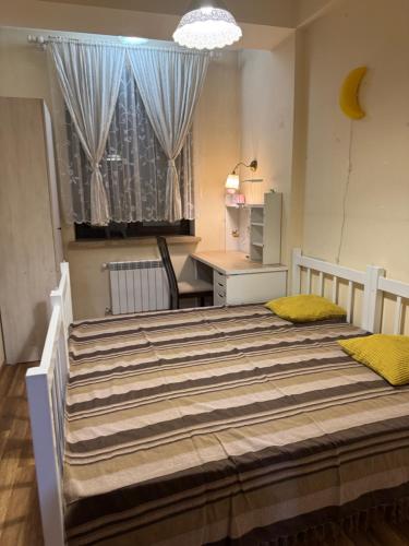 una camera da letto con letto, scrivania e finestra di Apartment a Yerevan