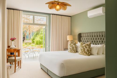 een slaapkamer met een bed en een groot raam bij Cape Vue Country House in Franschhoek