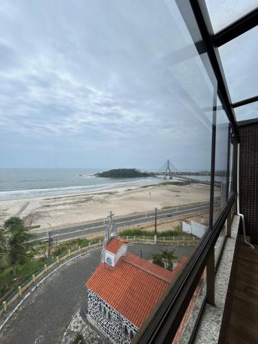 a view of a beach from a window of a building at Apartamento Outeiro in Ilhéus