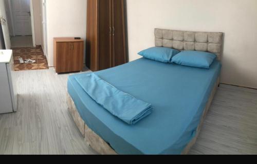 een groot bed met blauwe lakens en blauwe kussens bij Grand Aral Otel 
