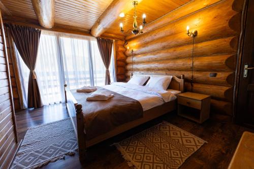 una camera con un letto in una baita di tronchi di Mocearu Retreat 