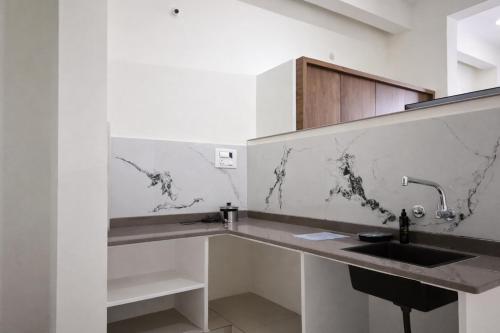 une cuisine avec un évier et un comptoir dans l'établissement Savi Service Apartments, à Chikmagalur