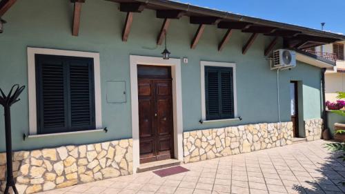 ein Haus mit einer Holztür und einer Steinmauer in der Unterkunft Ninetta in Aielli