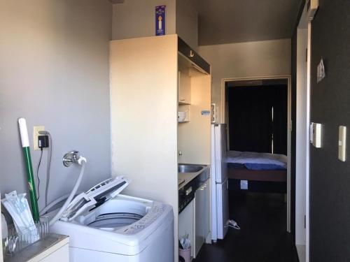 a small bathroom with a washing machine and a sink at LEGALCOURT - Vacation STAY 14717 in Akiruno