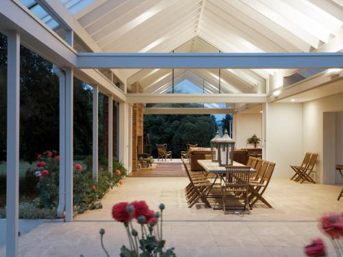 a conservatory with a table and chairs on a patio at Littlebourne Guest House in Bathurst