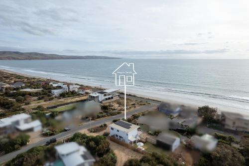 a house on the beach next to the ocean at Magpie Sands - Ocean Views & Seaside Luxury - Steps to beach in Aldinga Beach