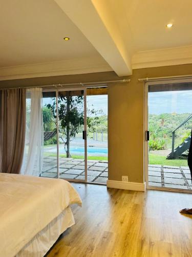 a bedroom with a bed and a large sliding glass door at Bonza Bay Bliss in East London