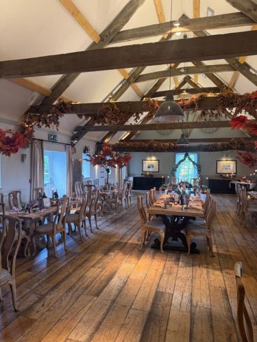 a dining room with wooden tables and chairs at The Farmhouse at Bodnant Welsh Food in Conwy