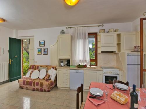 eine Küche und ein Wohnzimmer mit Sofa und Tisch in der Unterkunft Huge Holiday Home in Marina di Castagneto Carducci near Sea in Donoratico