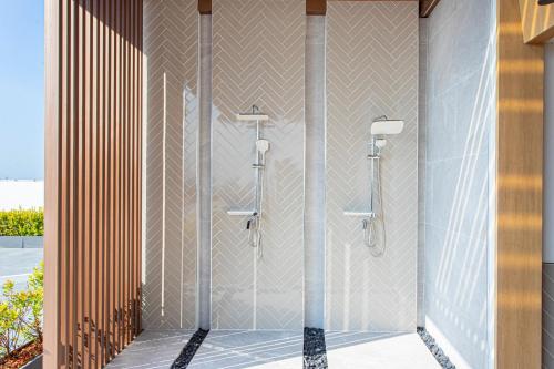um chuveiro numa casa de banho com uma parede em The1 Ratchaphruek I วิวเมืองนนทบุรี em Ban Nong Bua