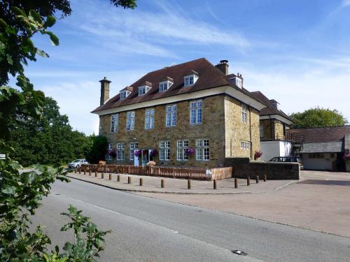 a large brick building on the side of a road at The Speech House in Coleford