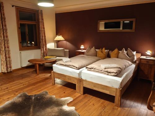 een woonkamer met twee bedden en een bank bij Pension zum Hirschstein in Greiz