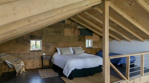 a bedroom in the attic of a log cabin at Cabaña Mirador de ballenas,Chiloé in Ancud