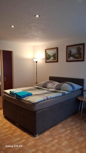 a large bed in a room with a lamp at Ferienwohnung Katharina in Ettenheim
