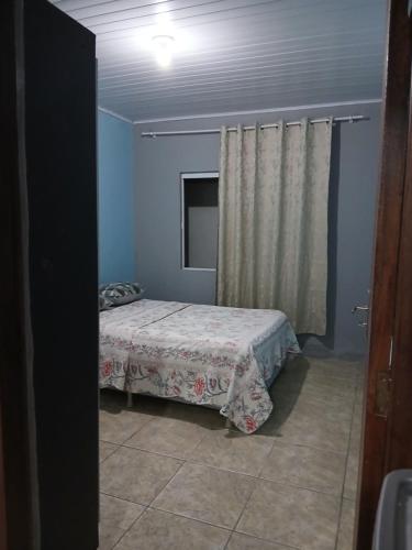 una camera da letto con un letto e una televisione di Kitnet e casa mobiliada a Penha