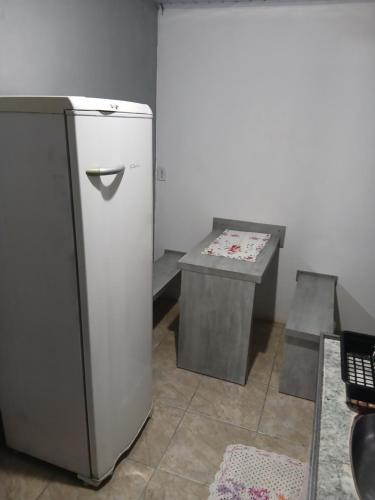 un piccolo frigorifero e un tavolo in camera di Kitnet e casa mobiliada a Penha
