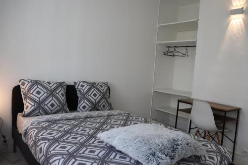 a bedroom with a bed and a desk and a chair at Les Erables Appart - 3 chambres - Spacieux et moderne avec balcon, parking et wifi in Saint-Jean-de-la-Ruelle