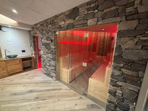 a stone bathroom with a shower in a stone wall at Chalet MAOL Luxury Living in Valdidentro