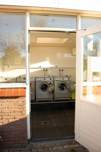 a garage with two washing machines inside of it at Het Strandnest in Renesse