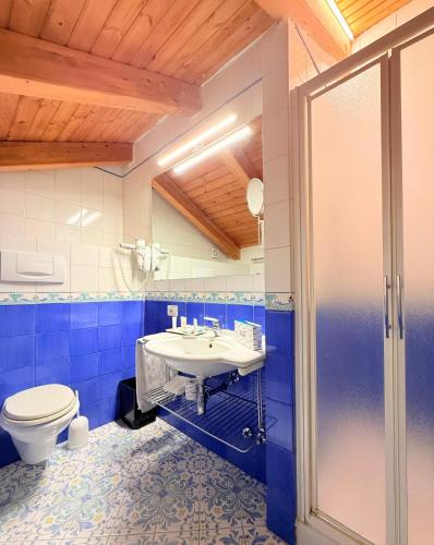 a blue bathroom with a toilet and a sink at Hotel Villa Maria in Sorrento