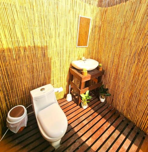 a bathroom with a toilet and a sink at Beach Moments Camp in Al Qārin
