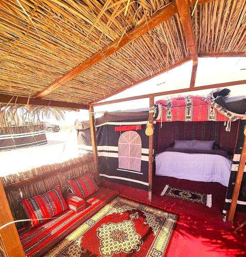 a room with a bed and pillows in a tent at Beach Moments Camp in Al Qārin