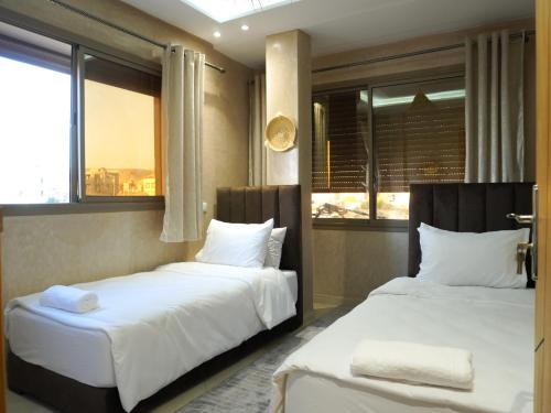 due letti in una stanza con due finestre di Shams House a Imsouane