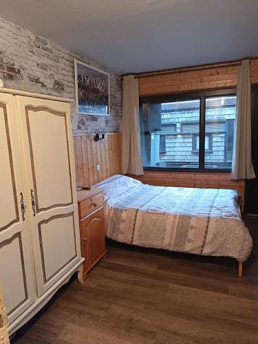 une chambre avec un lit et une fenêtre dans l'établissement Duplex montagne vue exceptionnelle, à Murat-le-Quaire