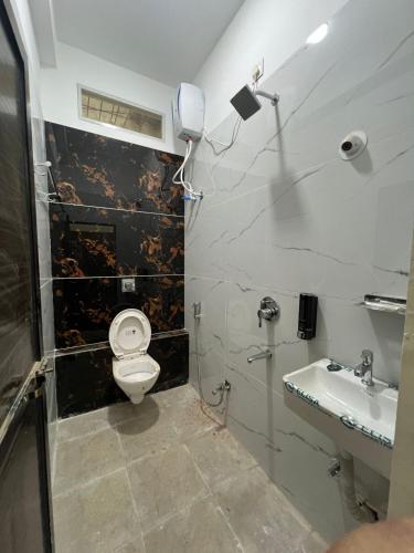 a bathroom with a toilet and a sink at Maheshwari Homes in Ujjain