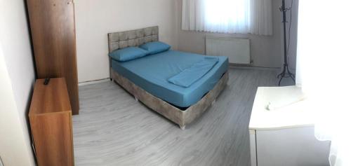een kleine slaapkamer met een bed met blauwe lakens bij Grand Aral Otel 