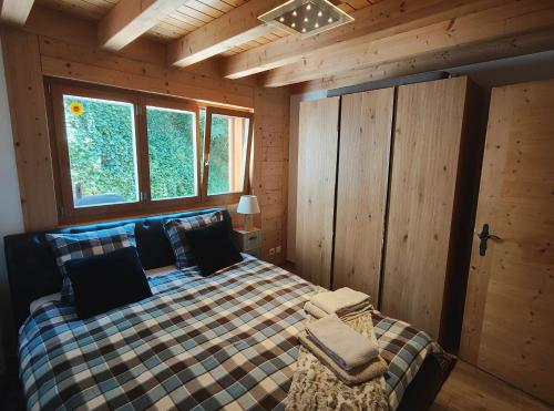 een slaapkamer met een bed in een blokhut bij Chalet l'O - Charm and Modernity in Leytron