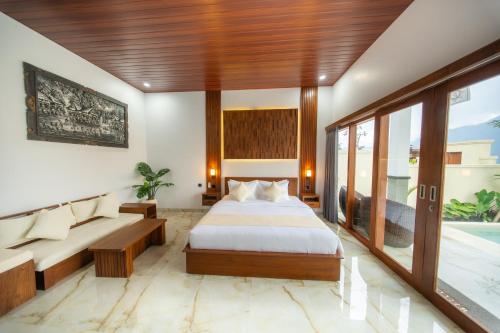 a hotel room with a bed and a couch at Batur Volcano Guest House & Villa in Kintamani