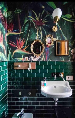 a bathroom with a sink and a mural at Tappetà perì in Campobasso