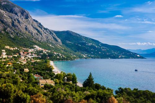 a view of a town on a hill next to the water at Nefeli Beach Home with Hot Tub - 100m to Beach in Barbati