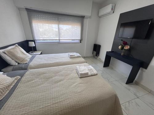 a bedroom with two beds and a flat screen tv at Apart Luro I in Santa Rosa