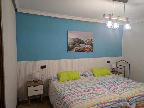 una camera da letto con due letti e una parete blu di Apartamento Toki Berriya a Elizondo