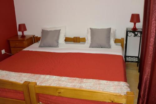 1 cama con manta roja y 2 almohadas en The Yellow House, en Vila Nova de Gaia