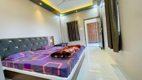 a bedroom with a bed with a purple comforter at Maa Rewa Palace in Sānāwad