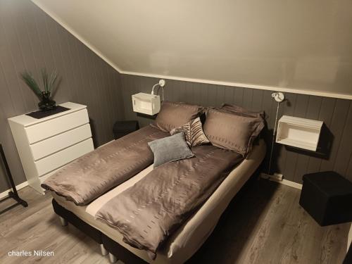 a bedroom with a large bed with pillows at Charles Country House in Solstad